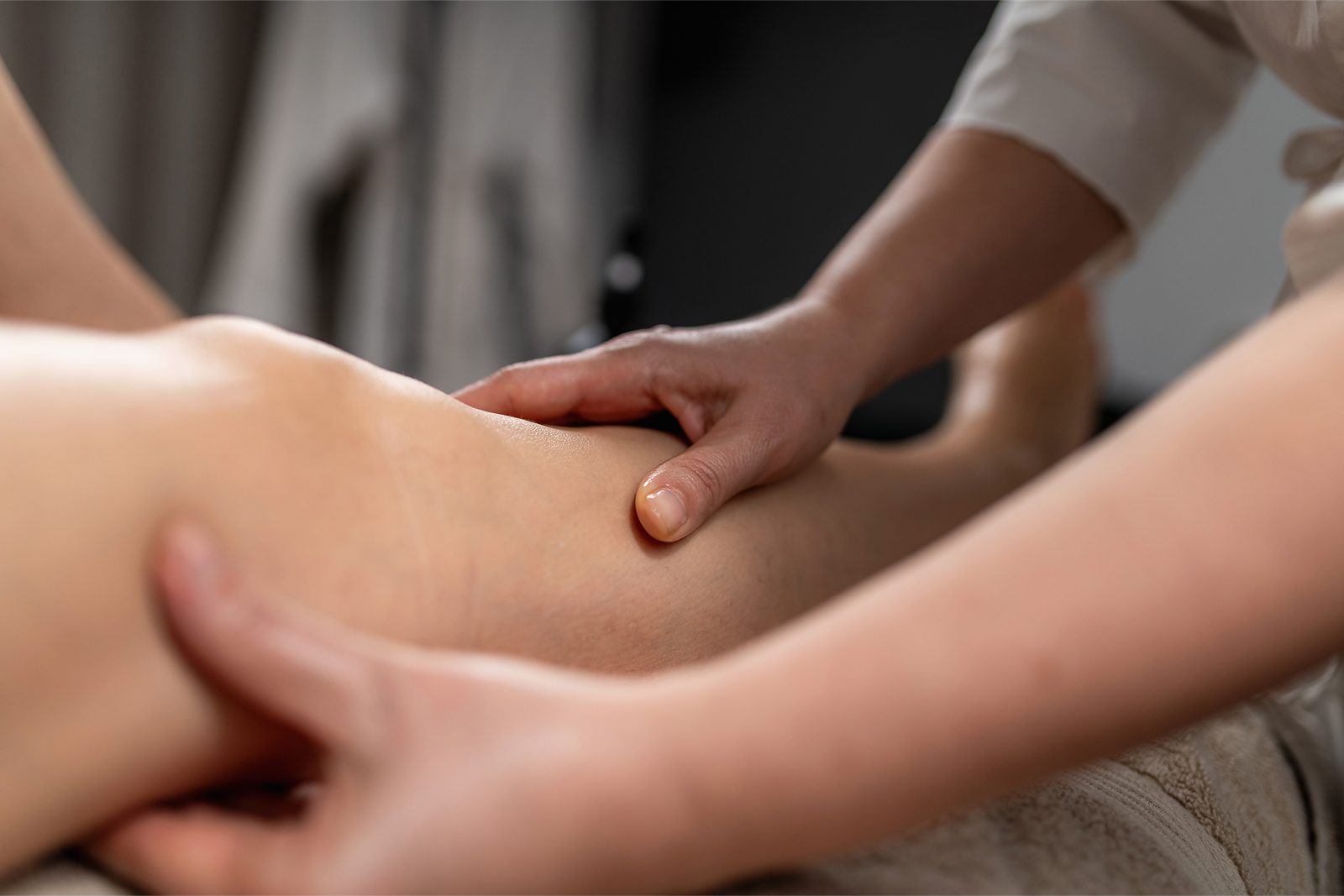 A professional therapist performing a gentle manual lymphatic drainage massage on a client at Alira Med Spa Houston.